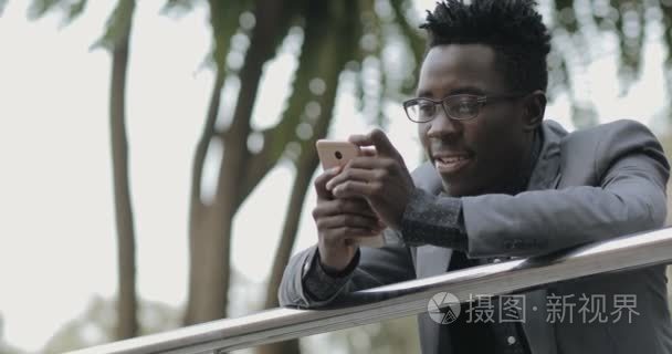 年轻的非洲商人用智能手机通话视频