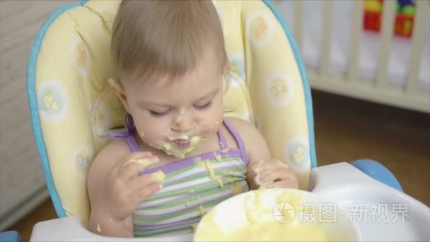 小的孩子独自吃婴儿食品用托盘蔓延到粥的勺子视频