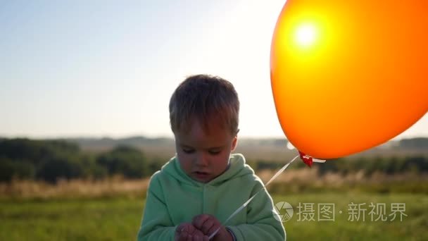 可爱的男孩站在气球中字段视频
