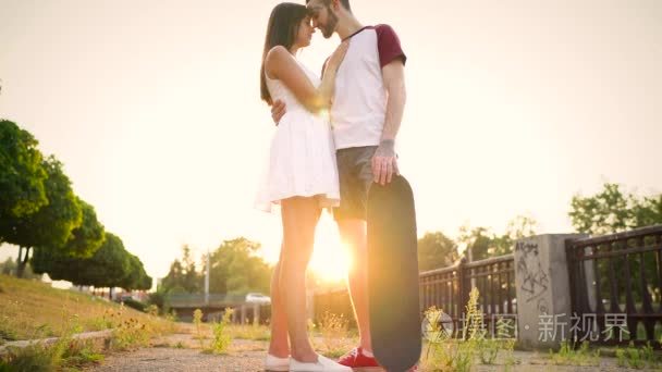 爱在日落时分在街上亲吻对年轻夫妇