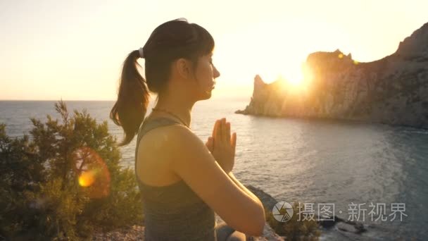 年轻女子在日落时的冥想视频