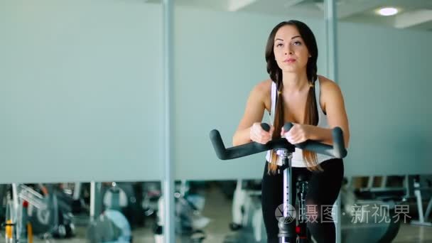有氧自行车的妇女训练视频