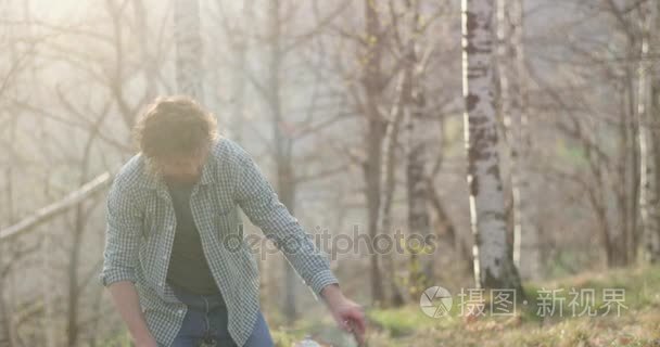 男人照明火灾在秋天旅行在把木材 logs.real 朋友人户外野营帐篷旅游度假。秋季晴天在性质、 团结和友谊。4 k 视频