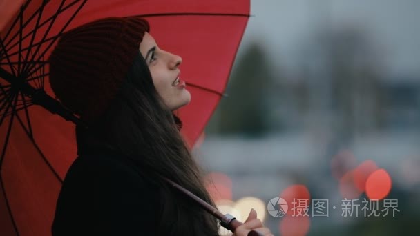 妇女在红色伞下制作手机照片视频