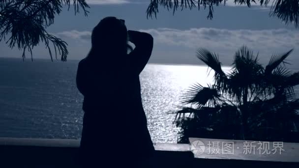 4k. 一棵棕榈树的剪影对海和天空背景, 热带海岛的看法, 海洋风景娱乐。女人在拍海的照片视频