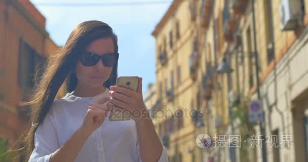 年轻美丽的妇女使用智能手机在欧洲城市