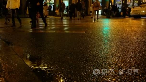 人们在雨夜的行人过路处过马路视频