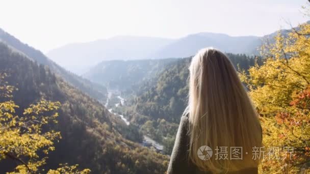 女女性站在悬崖上  看日出惊险  欣赏它。阳光照射到她  野生自然山峰的灵感享受美妙的地平线观光