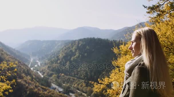 女女性站在悬崖上  看日出惊险  欣赏它。阳光照射到她  野生自然山峰的灵感享受美妙的地平线观光