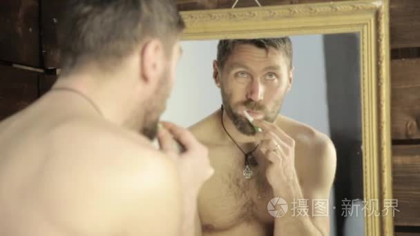 有胡子的人在浴室的镜子前刷牙视频