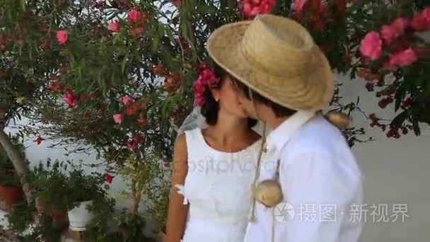 新娘和新郎在街上接吻。波西米亚风格。希腊