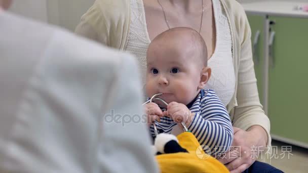 婴儿咬医生听诊器在医院体检视频