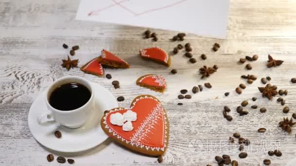 爱的关系。St. 的情人节概念。顶部的咖啡杯和姜饼心形是在木制背景与咖啡豆周围。女性手放爱留言注  4 k