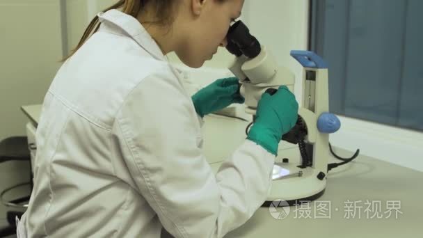 女生物学家在显微镜下看起来视频