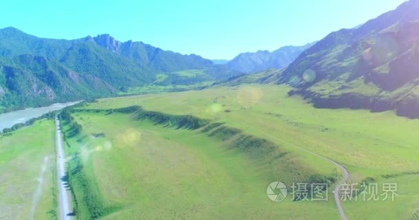 在晴朗的夏日清晨  空中的乡村山路和草地。沥青公路与河道