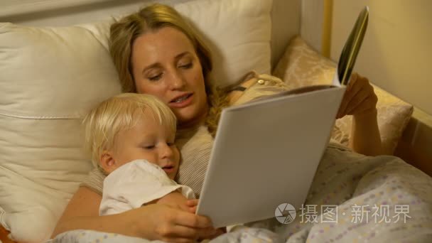母亲和儿子在床上看书视频