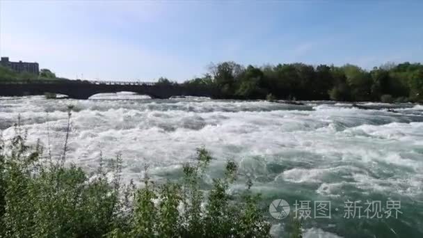 在美国瀑布与绿岛和山羊岛的背景下  从山羊岛桥到加拿大以外的瀑布  在尼亚加拉大河上冲水急流的手持平移视图