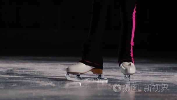 特写, 溜冰鞋的腿去冰和移动在框架。摄影机在溜冰鞋后面动态移动。专业花样滑冰视频