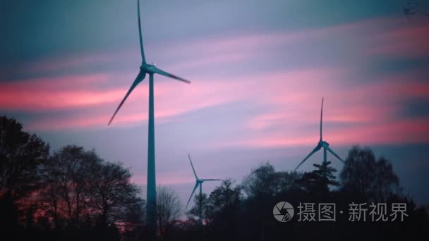 电力的夕阳的天空背景上的风车视频