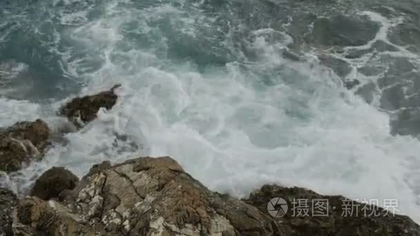 海浪拍打着黑山海滩上的岩石视频