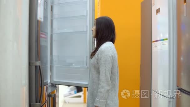 家电店的年轻女子选择冰箱