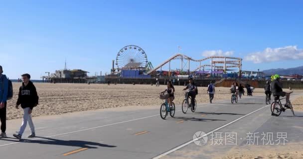 在圣莫尼卡海滩上骑车的人们视频
