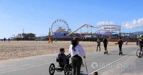 在圣莫尼卡海滩上骑车的人们视频