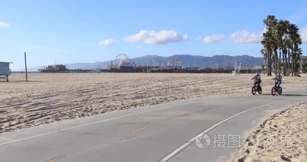 在圣莫尼卡海滩上骑车的人们视频