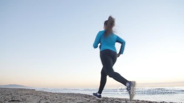 健身妇女赛跑者跑在海滩上视频