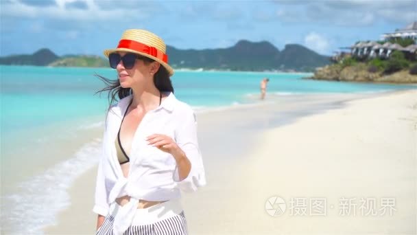 年轻时尚女性在海滩上的帽子视频