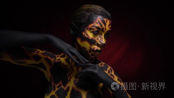 bodypainting 的女孩在火山熔岩的形象顺利移动身体, 慢动作