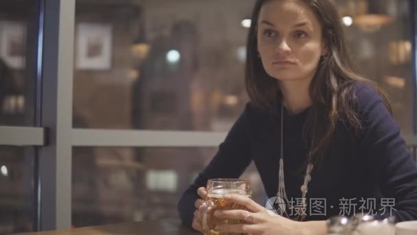 在咖啡馆喝啤酒的年轻妇女视频