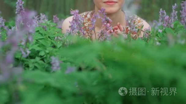 年轻美丽的妇女喜欢森林花视频