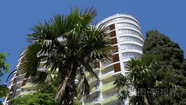 现代多层酒店与棕榈树蓝天视频