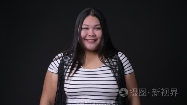 美丽的肥胖亚洲妇女反对黑背景视频