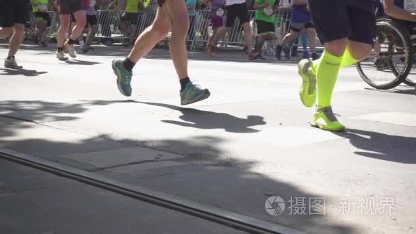 马拉松赛跑者的腿沿沥青跑视频