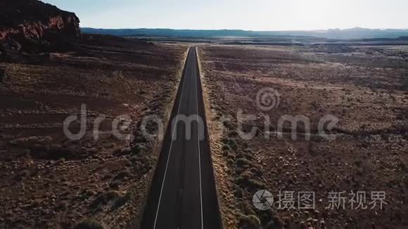在美国荒野的笔直沙漠公路上向前飞行，靠近巨大的岩石山和美丽的天空。