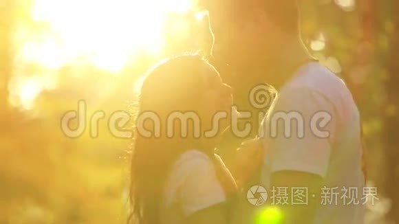 美丽的年轻夫妇在秋天公园相爱。 日落
