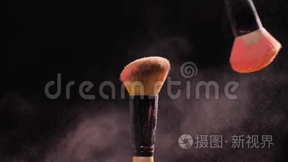 化妆品和美容的概念。 黑色背景上粉色粉末爆炸的化妆刷