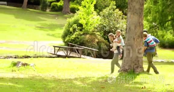 快乐的一家人一起在公园里玩追逐游戏