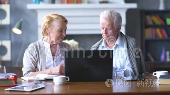 老年夫妇用笔记本电脑上网。 快乐的老人使用电脑