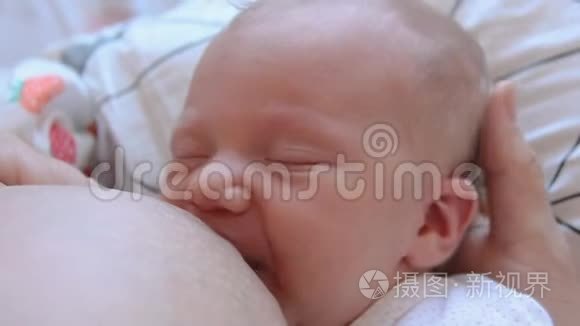 母亲抱着新生儿拥抱和母乳喂养她的婴儿，婴儿头部的特写，温柔和母亲的关怀。