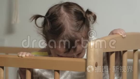 一个小孩子在婴儿床上玩耍。