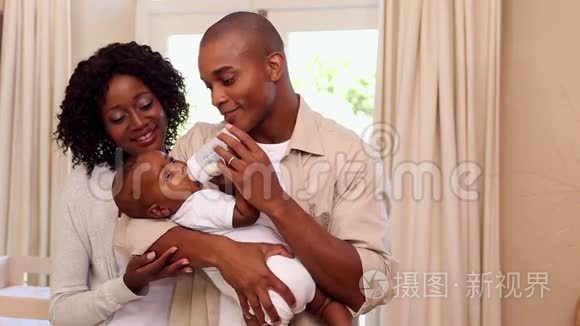 快乐的父亲喂婴儿和母亲