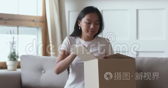 令人兴奋的亚洲女性消费者打开包裹箱接收装运订单