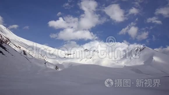 白雪覆盖的群山在云层和蓝天的背景下从一个车窗。 高加索，格鲁吉亚。