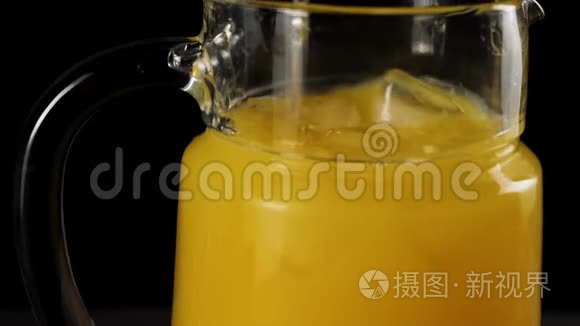 调酒师用勺子在黑色背景下，用一个缓慢运动的解码器搅拌新鲜橙汁冰块。