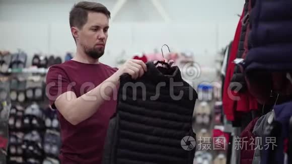 在店里挑选羽绒背心的男人视频