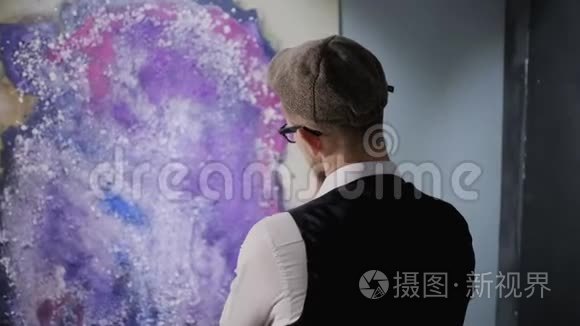 当代抽象艺术家展览的男性游客正在观看艺术品