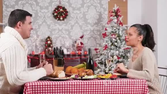 一对漂亮的高加索夫妇在客厅里享用圣诞晚餐